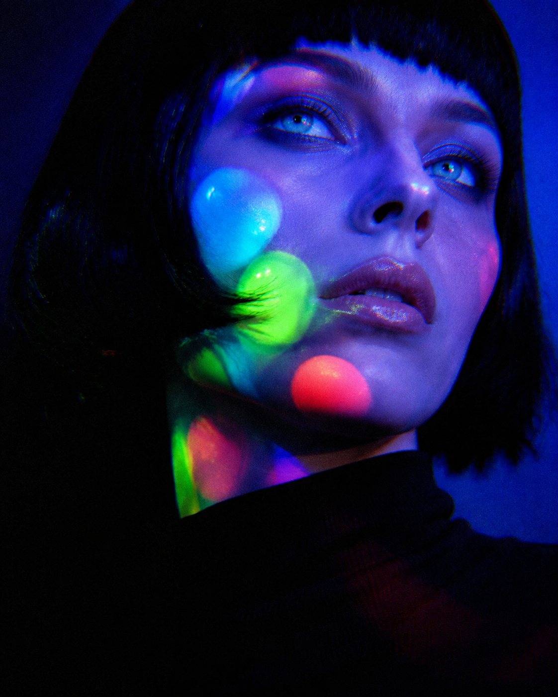 Gallery Lookbook centerfold portrait lit by saturated blue, green, and red projections